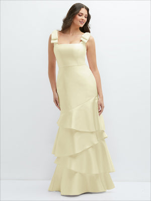 Light yellow satin maxi dress with bow shoulder straps and asymmetrical tiered ruffle hem