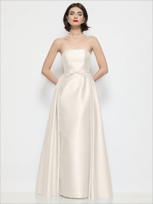 Ivory satin strapless column dress with bow at waist and overskirt overlay