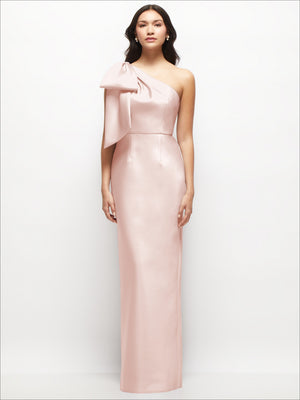 Blush pink one-shoulder satin column maxi dress with oversized bow on the shoulder