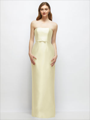Strapless satin column dress with skinny belt and bow trim, pale yellow, straight skirt.