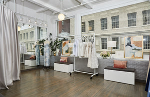 Dessy's New York showroom with framed photographs, seating and display shelves.