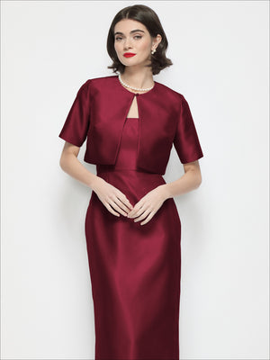 Cabernet red cropped satin jacket with jewel neckline, short sleeves, and front tab detail