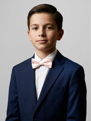 Boys bow tie worn with a navy blazer: soft pink satin bow with tied center knot.